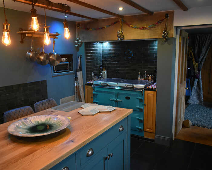 blue kitchen island with wood worktops